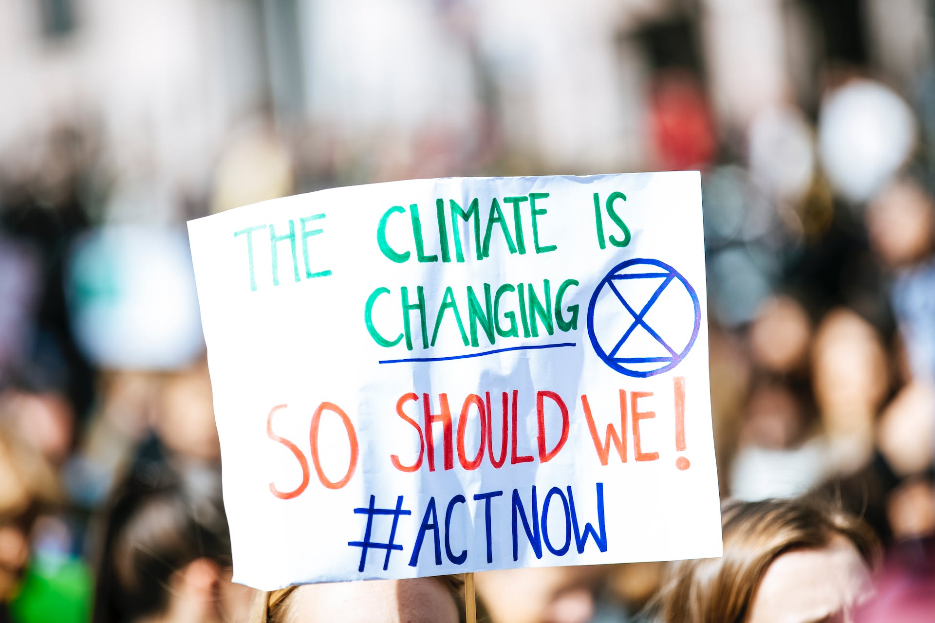 Climate change poster read as The climate is changing so should we. hashtag used with act now